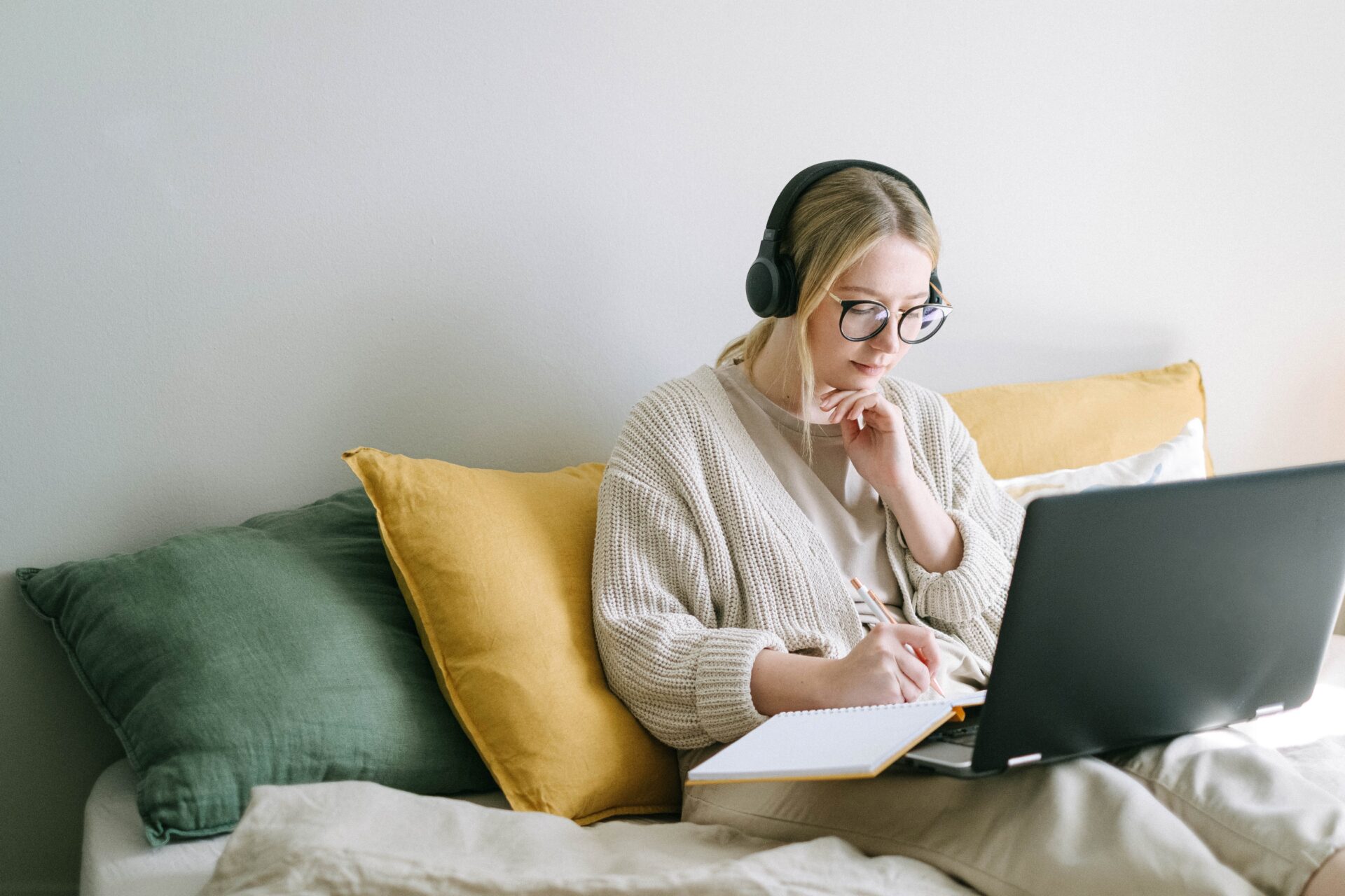 lady sitting and looking at laptop while writing