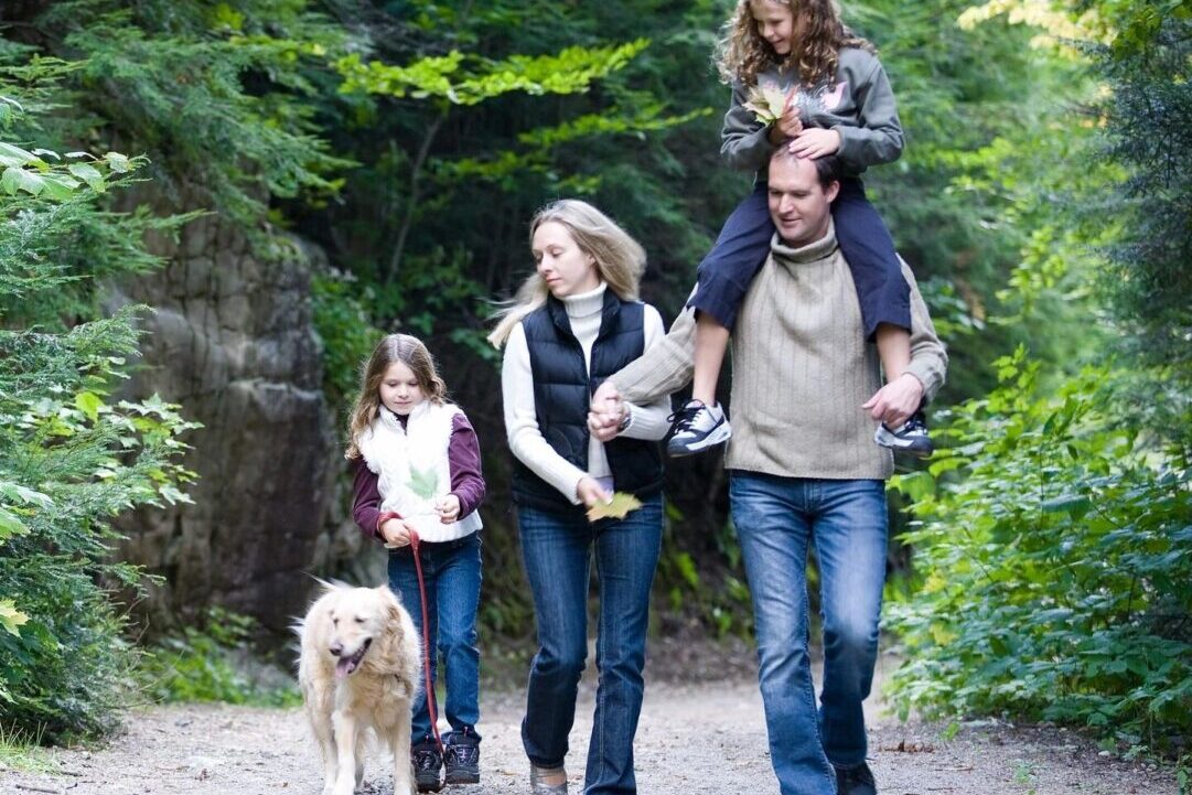 family walking down trail with dog 