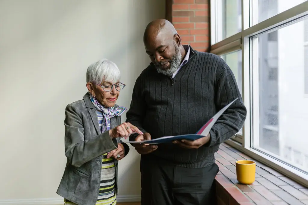 man and woman looking at book 