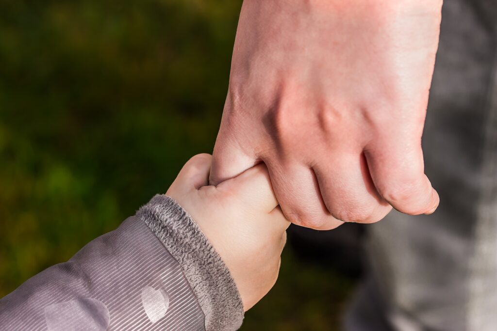 adult holding a Childs hand