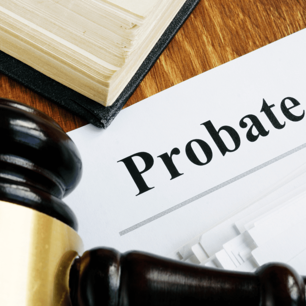 judges hammer and piece of paper with the word "probate" and partial book, all laying on a wooden desk