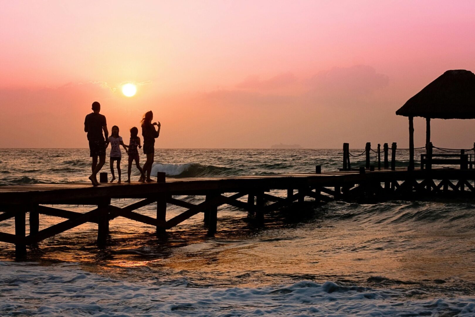 family in the sunset on beach dock pier 