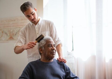 Caregiver brushing mans hair